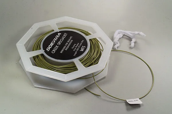 Fly line ready - Most fly line spools can be taken apart, after which you can easily remove the thread or twists that might hold the line. But don't be tempted to remove the line from the spool. Leave it on the spool while you wind the line on the reel.
Notice the small sticker indicating the reel end of the line. On a weight forward line you will definitely want that end to attach to the backing.